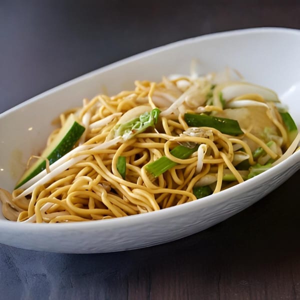 Lotus Xpress chow mein with noodles, bean sprouts, onions, and green vegetables in a white bowl.